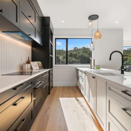 Kitchen photo, white and black cabinets with light engineering stone bench top.